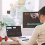 Young woman sitting at desk editing videos with InVideo ai text-to-video tool